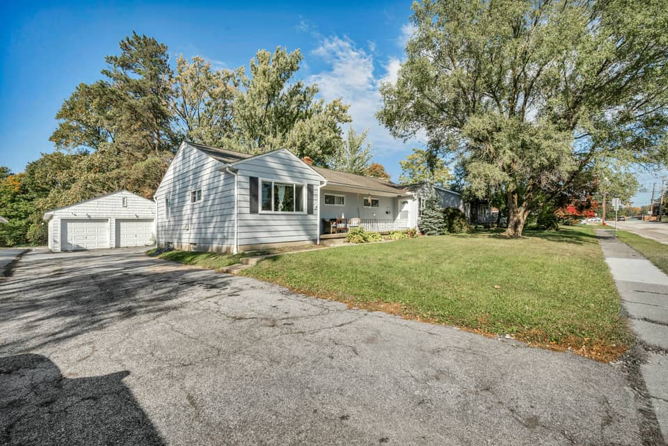 A ranch house with a detached two-car garage at the end of a wide driveway